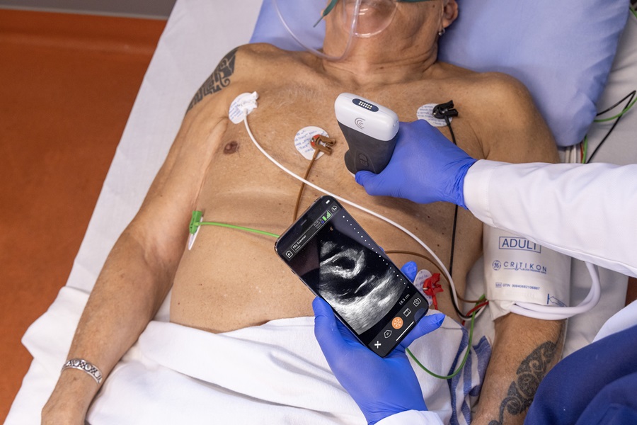 ultrasound device being used on patient chest while seeing visual on smart phone