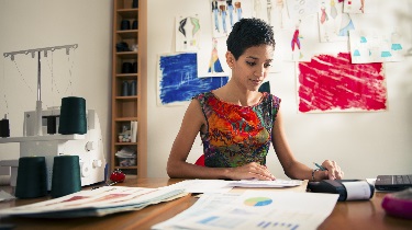 A woman works on cash flow challenges in her home office.