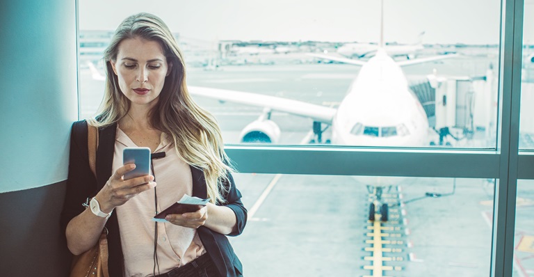 Female exporter looks at phone in airport
