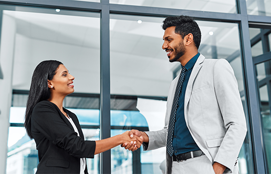 a business woman and man are shaking hands