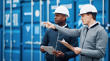 Two exporters discuss shipment in front of container
