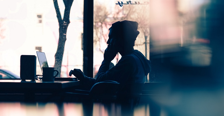 Man working in the shadows on his laptop