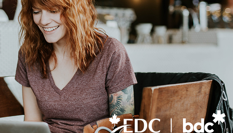 A young business owner in a cafe sells online using her laptop.